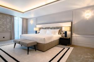 a bedroom with a king sized bed and a chair at Amoure Hotel - The Leading Hotels of the World in Braga