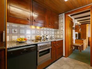 a kitchen with wooden cabinets and a stove top oven at Apartment Residenza Chesa Margun 77-2 by Interhome in Surlej