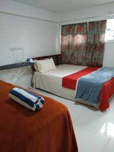 a bedroom with two beds with red and blue blankets at Mead Road Homestay Tours &Transfers Deluxe Flat 1 Bedroom in Suva