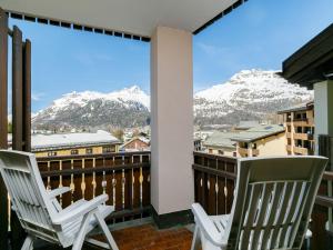 two chairs on a balcony with snow covered mountains at Apartment Residenza Chesa Margun 78-4 by Interhome in Surlej