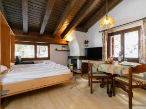 een slaapkamer met een bed, een bureau en een tafel bij Apartment Residenza Chesa Margun 710-4 by Interhome in Surlej