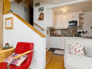 ズルレイにあるApartment Residenza Chesa Margun 35-6 by Interhomeの赤い椅子とキッチンのあるリビングルーム