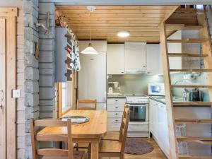 a kitchen with a wooden table and a kitchen with a ladder at Holiday Home Isonparit b3 by Interhome in Ylläsjärvi