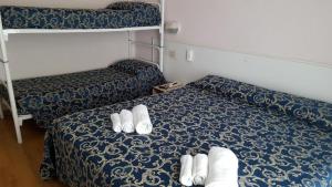 um pequeno quarto com uma cama com chinelos em Little Hotel em Riccione