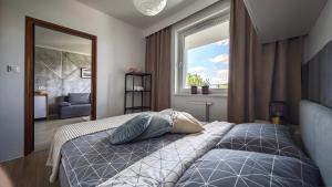a bedroom with a bed and a window at NOWOCZESNY APARTAMENT MODERNO 2020 - Szczecinek in Szczecinek