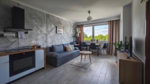 a living room with a couch and a table at NOWOCZESNY APARTAMENT MODERNO 2020 - Szczecinek in Szczecinek