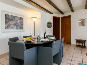 ein Esszimmer mit einem Tisch mit Stühlen und einer Flasche Wein in der Unterkunft Apartment Residenza Chesa Margun 66-1 by Interhome in Surlej