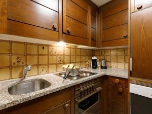 eine Küche mit Holzschränken und einem Waschbecken in der Unterkunft Apartment Residenza Chesa Margun 66-1 by Interhome in Surlej