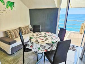 a dining room with a table and chairs and a couch at Apartment Snježana-3 by Interhome in Zavalatica