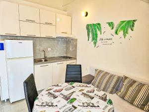 a small kitchen with a table and a refrigerator at Apartment Snježana-3 by Interhome in Zavalatica +10 photos