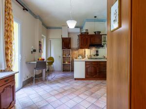 Una cocina con gabinetes de madera y una mesa en ella. en Holiday Home Atelier-2 by Interhome, en Invorio Inferiore