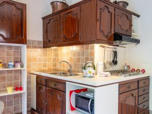 Una cocina con gabinetes de madera y microondas. en Holiday Home Atelier-2 by Interhome, en Invorio Inferiore