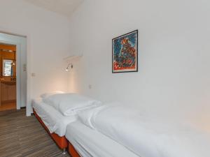 una camera bianca con un letto e una foto appesa al muro di Apartment Kern by Interhome a Bad Hofgastein