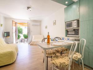 Una cocina y una sala de estar con mesa y sillas. en Apartment Le Lido-3 by Interhome, en Les Lecques