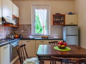 Una cocina con una mesa con un bol de fruta encima. en Holiday Home Atelier-1 by Interhome, en Invorio Inferiore