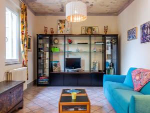 Una sala de estar con un sofá azul y un televisor. en Holiday Home Atelier-1 by Interhome, en Invorio Inferiore