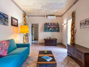 Una sala de estar con un sofá azul y una mesa. en Holiday Home Atelier-1 by Interhome, en Invorio Inferiore