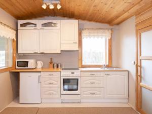 cocina blanca con armarios blancos y ventana en Holiday Home Havukka by Interhome, en Visulahti