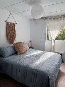 a bedroom with a bed with a blue blanket and a window at Casa O Coto in Grañas