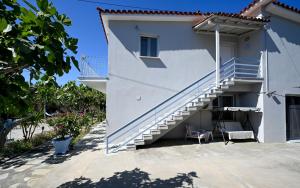 a white house with stairs and a chair at Anchor Villa in Skiathos Town