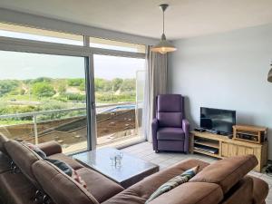 Una sala de estar con un sofá, una mesa y un televisor. en Apartment Ref 602 by Interhome, en Bredene