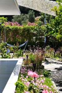 a garden with flowers and a pink bird in the middle at Anchor Villa in Skiathos Town