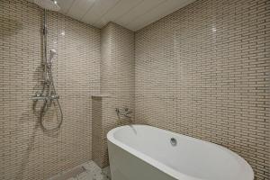a bathroom with a bath tub and a shower at Birupaku in Shizuoka