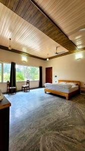 a large room with a bed and a table at The Greenwich resort in Rāmnagar