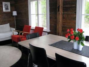a room with a table with red chairs and a vase of flowers at Holiday Home Säikkäranta by Interhome in Oulunsalo