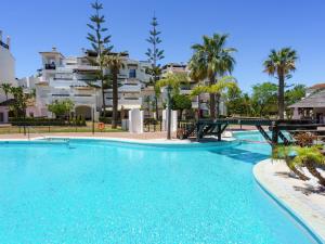 een groot zwembad met een gebouw op de achtergrond bij Apartment Las Adelfas by Interhome in Marbella +36 foto's
