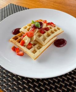 a white plate with a waffle with fruit on it at Kos Bulan Bali in Kuta