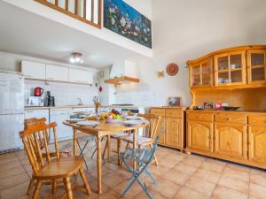 - une cuisine avec une table et des chaises en bois dans l'établissement Apartment Les Mimosas by Interhome, aux Lecques
