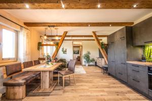 eine Küche und ein Esszimmer mit einem Holztisch und Bänken in der Unterkunft Chalet Waldzeit in Zachenberg