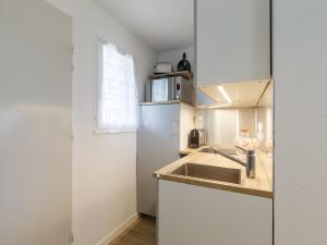 eine Küche mit einer Spüle und einem Kühlschrank in der Unterkunft Apartment Les Balcons de l'Atlantique-15 by Interhome in Vaux-sur-Mer