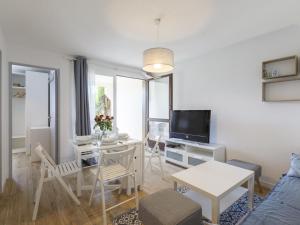 ein Wohnzimmer mit einem Tisch und einem TV in der Unterkunft Apartment Les Balcons de l'Atlantique-15 by Interhome in Vaux-sur-Mer