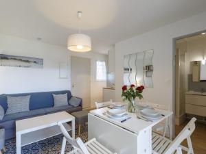 ein Wohnzimmer mit einem Tisch und einem blauen Sofa in der Unterkunft Apartment Les Balcons de l'Atlantique-15 by Interhome in Vaux-sur-Mer