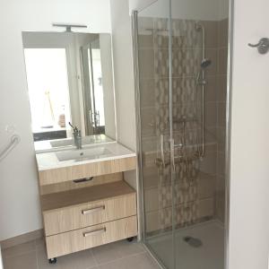 a bathroom with a sink and a shower at Cosy Diem Cap d'Agde in Cap d'Agde