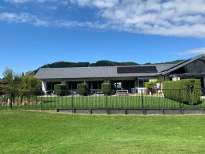 a building with a fence in front of a yard at Parkside Boutique Lodge in Rotorua
