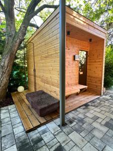 een houten sauna met een boom op de achtergrond bij Hello Balaton in Alsóörs