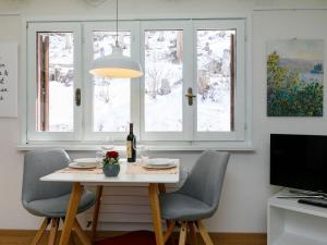 a dining room with a table and chairs and windows at Apartment Residenza Chesa Margun 710-5 by Interhome in Surlej