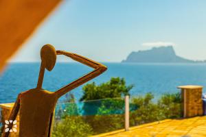 Una silla de madera con vistas al océano. en Villa Diana by Abahana Villas, en Cap Blanc