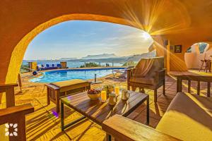 sala de estar con mesa y vistas al agua en Villa Diana by Abahana Villas, en Cap Blanc