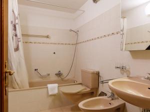 a bathroom with a toilet and a sink and a tub at Apartment Residenza Chesa Margun 78-1 by Interhome in Surlej