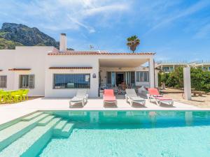 a villa with a swimming pool in front of a house at Holiday Home Xoroi by Interhome in Colonia de Sant Pere