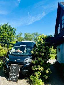 a van parked next to a sign next to a bush at Kåseberga Hideout in Kåseberga