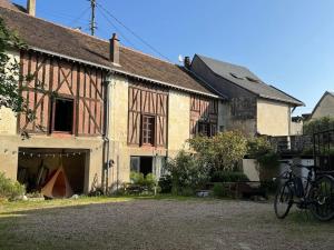 an old house with a bike parked in front of it at La Belle Étoile in La Chartre-sur-le-Loir