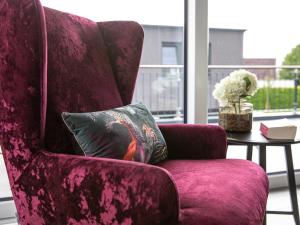 a purple chair with a pillow and a table at Holiday Home Fischer sien Huus-7 by Interhome in Fedderwarderdeich