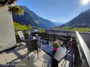 a balcony with tables and chairs and a view of mountains at beb Aria di Montagna in Forcola