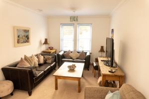 sala de estar con sofá y TV en Lovely Holiday Home In The East Neuk Of Fife, en Anstruther