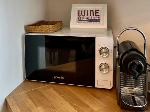 a microwave sitting on a counter next to a toaster oven at Barik Lak - Érezd jól magad! családbarát szállás in Villány